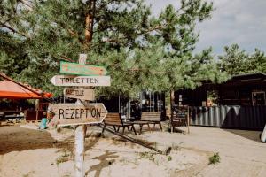 a pole with street signs in front of a tree at raus und gut Glamping am Gräbendorfer See in Drebkau