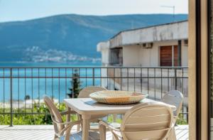 una mesa y sillas en un balcón con vistas al océano en Boka Apartment 6 en Herceg-Novi