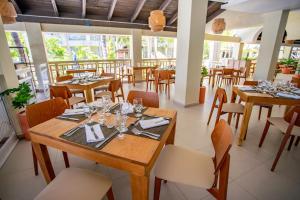 comedor con mesas y sillas de madera en Coral Costa Caribe Beach Resort - All Inclusive, en Juan Dolio