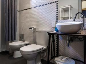 uma casa de banho com um WC branco e um lavatório. em CracWoW Market Squere Apartment em Cracóvia