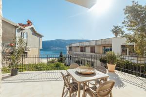 a patio with a table and chairs on a balcony at Boka Apartment 6 in Herceg-Novi