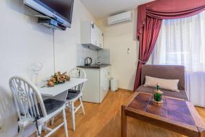 ein kleines Wohnzimmer mit einem Tisch und einer Küche in der Unterkunft APP BENI in Crikvenica
