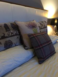 Una cama con almohadas y una almohada. en Strath View on the NC 500 en Culbokie