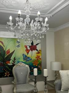 a chandelier in a living room with a painting at Casa hermosa amoblada norte de Valledupar in Valledupar