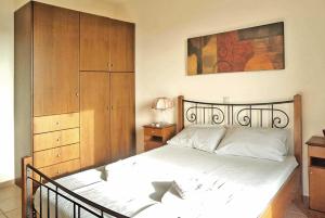 ストウパにあるPanorama Stoupa Peloponneseのベッドルーム1室(ベッド1台付)、木製キャビネットが備わります。