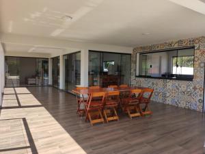 uma sala de jantar com uma mesa e cadeiras de madeira em Casa com vista incrível para o Lago de Furnas em Capitólio