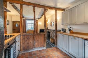 uma cozinha com armários brancos e uma porta de madeira em Cragg Cottage em Lindale
