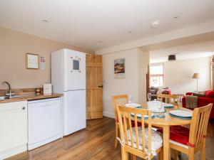 a kitchen and dining room with a table and a white refrigerator at The Old Bothy in Wigton
