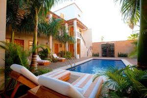 a swimming pool with lounge chairs and a house at Hotel Casa Tota in Todos Santos