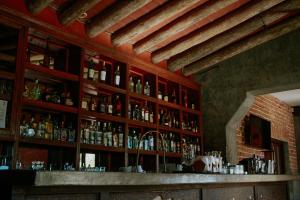 - un bar avec de nombreuses bouteilles d'alcool sur le mur dans l'établissement Hotel Casa Tota, à Todos Santos