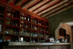 トドス・サントスにあるHotel Casa Totaの壁にたくさんのアルコール飲料を取り揃えたバー