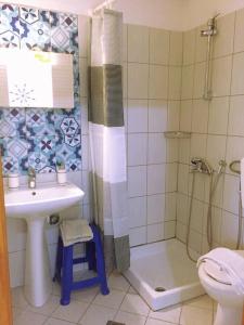 bagno con lavandino, doccia e servizi igienici di Port Rooms a Limenas