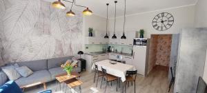 a living room with a couch and a table and a kitchen at Central Apartments Astoria 2 in Gdańsk