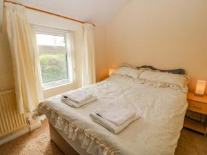 een slaapkamer met een bed met handdoeken erop bij Tir Bedw in Ederyn