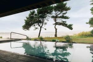 a pool with a view of the ocean and trees at Salishan Coastal Lodge by SCP Hotels in Lincoln City