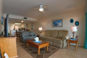 a living room with two couches and a tv at Sea Club Condo #103 in Clearwater Beach