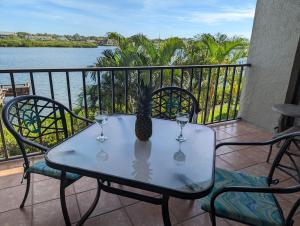 a table with two wine glasses and a pineapple on it at Sea Club Condo #103 in Clearwater Beach