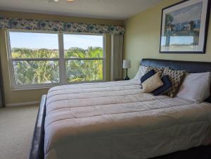 a bedroom with a large bed with a large window at Sea Club Condo #103 in Clearwater Beach