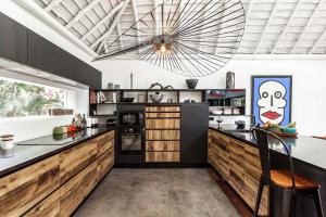 a kitchen with wooden cabinets and a large chandelier at THE VILLA BY THE SEA Nouvelle-Caledonie in Mont-Dore