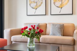 a vase of red roses on a table in a living room at Swiss Hotel Apartments - Lugano in Lugano