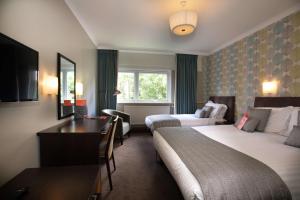a hotel room with two beds and a desk at The Lincoln Hotel in Lincoln +60 photos