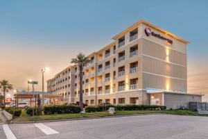 加尔维斯敦Best Western Plus Galveston Suites的一家酒店，前面有个停车场