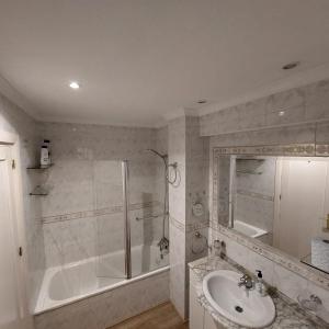 a bathroom with a shower and a tub and a sink at Apartamento frente a la playa Piso 2 in Estepona