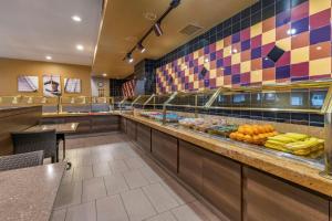 a restaurant with a counter with fruits and vegetables at Best Western Plus Park Place Inn - Mini Suites in Anaheim