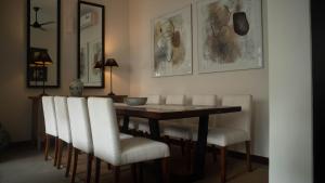 a dining room with a table and white chairs at Havelock Gardens BnB in Colombo