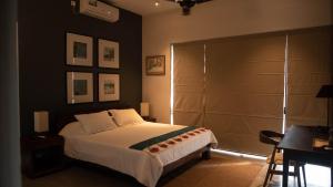 a bedroom with a bed and a table and a desk at Havelock Gardens BnB in Colombo
