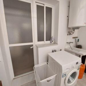 a bathroom with a washing machine and a sink at Apartamento frente a la playa Piso 2 in Estepona +11 photos
