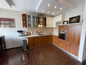 a large kitchen with wooden cabinets and a sink at Riverside Luxury Apartment in Osijek