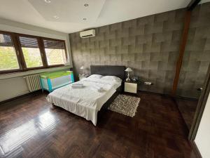 a bedroom with a bed and wooden floors and windows at Riverside Luxury Apartment in Osijek