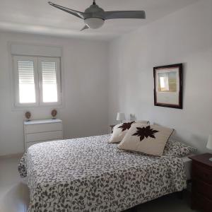 a bedroom with a bed and a ceiling fan at Apartamento frente a la playa Piso 3 in Estepona