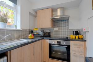 a kitchen with a sink and a stove top oven at Cannock 3 bedroom house - perfect for work or leisure in Great Wyrley