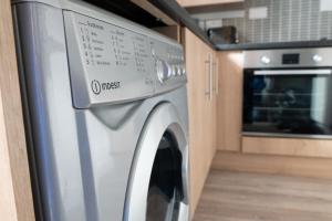 una lavadora de acero inoxidable en una cocina en Cannock 3 bedroom house - perfect for work or leisure, en Great Wyrley