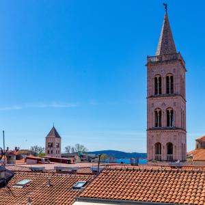 wieża zegarowa na szczycie budynku z dachem kaflowym w obiekcie Bobo central 2BR apartment w mieście Zadar
