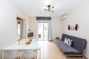 a living room with a couch and a table at Psirri Place economy apartments centrally located in Athens