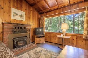 sala de estar con chimenea y TV en Masoods Lodge, en Boulder Creek