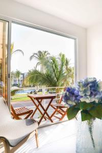 um quarto com uma varanda com uma mesa e flores em Beautiful Apartment in Dream Acapulco Diamante em Acapulco
