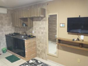 a kitchen with a sink and a tv on a wall at The Best - Ponta Verde in Maceió