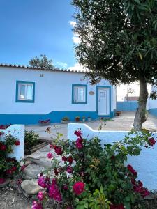 una casa azul con flores delante en Casa da Cerca, en Corte do Pinto