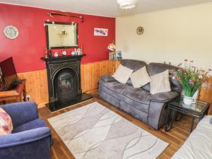 a living room with a couch and a fireplace at Rambler's Rest in Manorhamilton