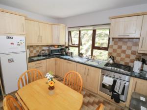 a kitchen with a wooden table and a table and chairs at Rambler's Rest in Manorhamilton