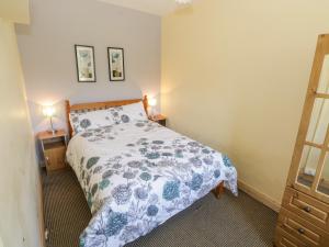 a bedroom with a bed with a blue and white comforter at Rambler's Rest in Manorhamilton