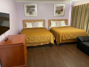 Habitación de hotel con 2 camas y sofá en Niagara Holiday Apartment, en Niagara Falls