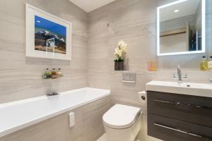 a bathroom with a tub and a toilet and a sink at The Barclay Apartment in Perth