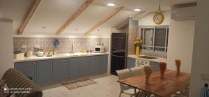 a kitchen with blue cabinets and a wooden table at סוויטת בוטיק in Netivot