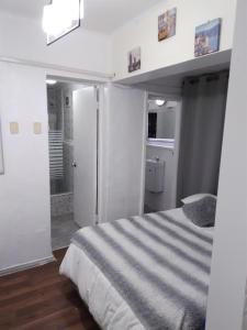 a white bedroom with a bed and a bathroom at Hostal Casamar-Viña in Viña del Mar