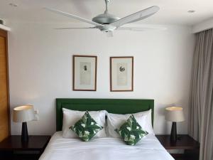 a bedroom with a white bed with a ceiling fan at Beachfront 2 BR Luxury Condo Chava Surin in Surin Beach